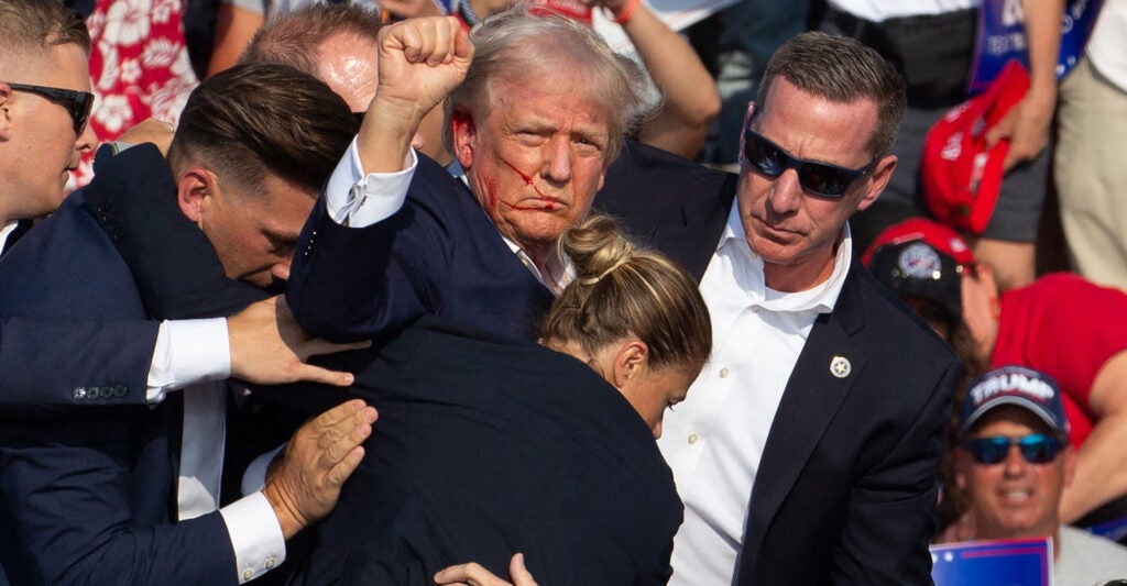 Donald Trump surrounded by Secret Service agents as he is taken off the stage at a campaign event after an assassination attempt in Butler, Pennsylvania, July 13, 2024. (Rebecca Droke/AFP via Getty Images)