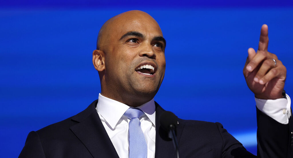 Colin Allred in a black suit with a blue tie