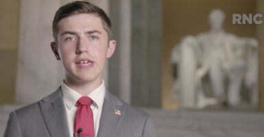 Nick Sandmann in a suit in front of Abraham Lincoln