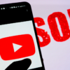 The YouTube logo is displayed on a smartphone with the word “CENSORED” displayed in the background.