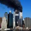 The twin towers of the World Trade Center in New York City billow smoke.