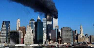 The twin towers of the World Trade Center in New York City billow smoke.