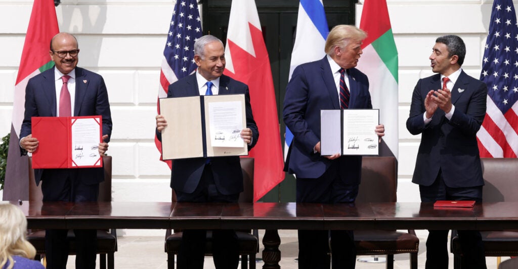 Donald Trump, Benjamin Netanyahu, and leaders from the United Arab Emirates and Bahrain outside the White House holding up signed copies of the Abraham Accords