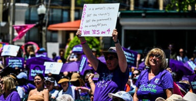 Pro-abortion protesters hold signs.