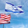 U.S. and Israeli flags flying against a cloudy blue sky backdrop