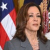 kamala Harris in a suit with an American flag Behind her