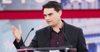 Ben Shapiro gestures in a suit at CPAC