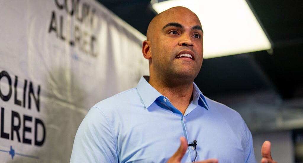 Colin Allred in a blue dress shirt gestures