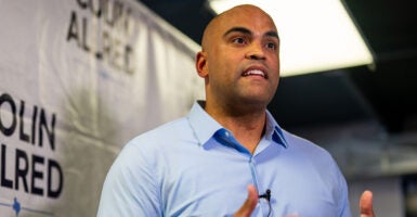 Colin Allred in a blue dress shirt gestures