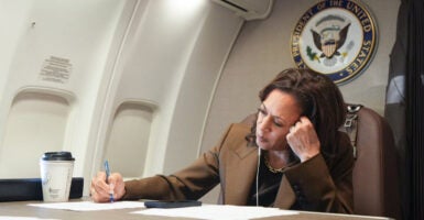 Vice President Kamala Harris in brown suit inside an airplane.