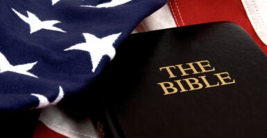 The Bible resting on an American Flag. (kledge/Getty Images)