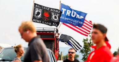 A veterans flag and a flag supporting U.S. Republican Presidential nominee former President Donald Trump fly outside a rally for Trump at the Brick Breeden Fieldhouse at Montana State University on August 9 in Bozeman, Montana. (Michael Ciaglo/Getty Images)