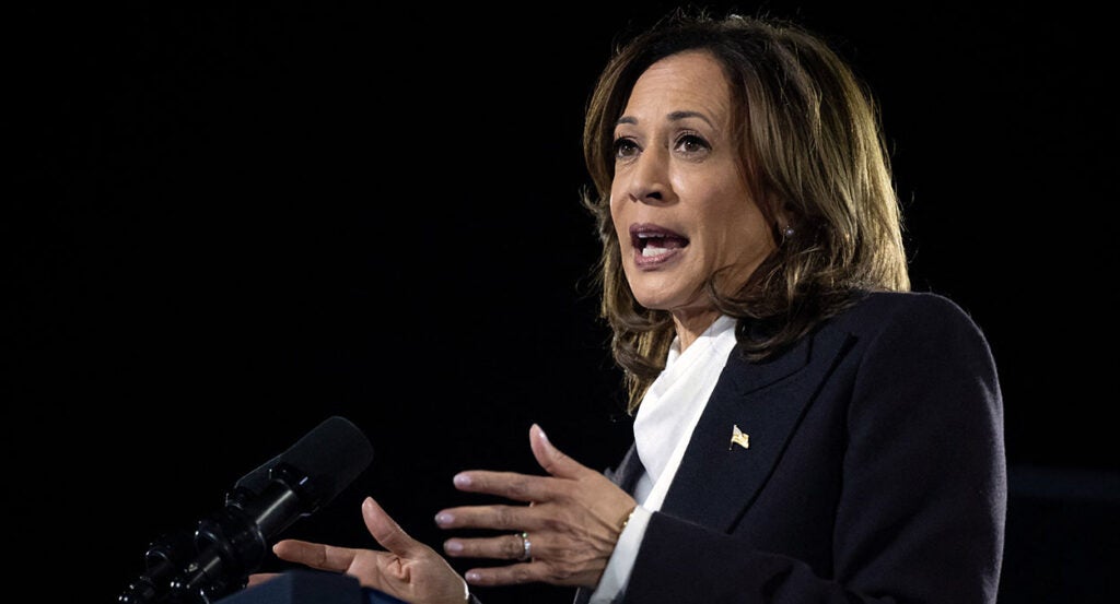 Kamala Harris in a black suit gestures