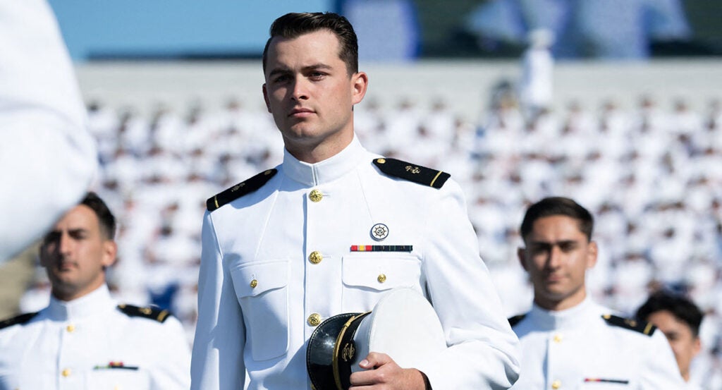 Naval Academy midshipmen line up for graduation in white uniforms