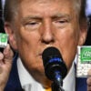 Donald Trump At a microphone holds a big and a small box of Tic-Tac mints to illustrate inflation