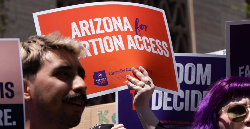 Abortion protestors hold up signs saying "Arizona for Abortion Access"