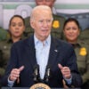 Joe Biden at a podium giving remarks in front of several uniformed border patrol officers