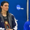 Biological male Lia Thomas dressed as a female swimmer standing next to Riley Gaines at a swimming championship