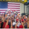 Sen. JD Vance speaks at a factory with a large American flag as his backdrop.