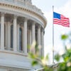 The U.S. Capitol Building with a U.S. flag flying on a pole outside.