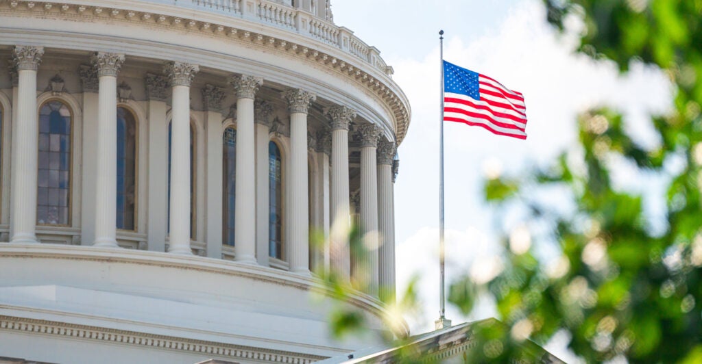 The U.S. Capitol Building with a U.S. flag flying on a pole outside.