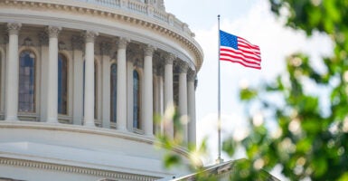 The U.S. Capitol Building with a U.S. flag flying on a pole outside.