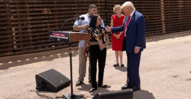 Donald Trump next to the border fence in Arizona with the mother of a young girl who was killed by illegal aliens