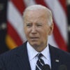 US President Joe Biden, in a suit, stands before the United States flag and addresses the nation following Trump's 2024 presidential election victory.