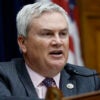 Representative James Comer in a gray suit and red tie and a microphone in a House committee meeting