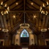 The interior of Parish Life Center in Houston, Texas, with stained glass windows and candles