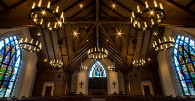 The interior of Parish Life Center in Houston, Texas, with stained glass windows and candles