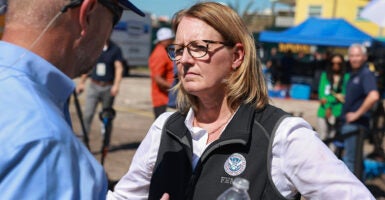 Deanne Criswell scowls in a vest with the FEMA logo