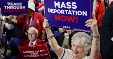 MILWAUKEE, WISCONSIN - JULY 17: People hold signs that read "Mass Deportation Now!" on the third day of the Republican National Convention at the Fiserv Forum on July 17, 2024 in Milwaukee, Wisconsin. Delegates, politicians, and the Republican faithful are in Milwaukee for the annual convention, concluding with former President Donald Trump accepting his party's presidential nomination. The RNC takes place from July 15-18. (Photo by Alex Wong/Getty Images)