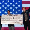 SpaceX and Tesla founder Elon Musk awards Judey Kamora with $1,000,000 during an America PAC town hall on October 26, 2024 in Lancaster, Pennsylvania. (Samuel Corum/Getty Images)