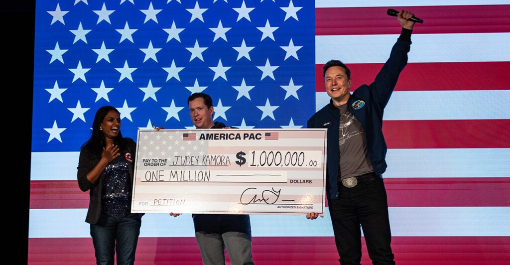 SpaceX and Tesla founder Elon Musk awards Judey Kamora with $1,000,000 during an America PAC town hall on October 26, 2024 in Lancaster, Pennsylvania. (Samuel Corum/Getty Images)