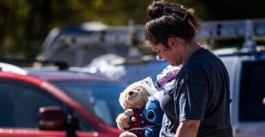 Dejected woman walks in the aftermath of Hurricane Helene