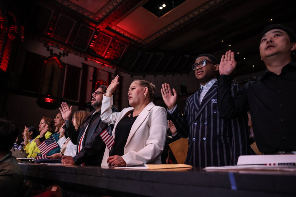 A group of immigrants raise their right hand as they are sworn in as U.S. citizens.