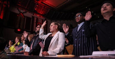 A group of immigrants raise their right hand as they are sworn in as U.S. citizens.