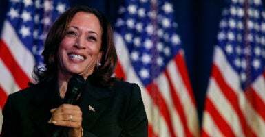 Kamala Harris speaks in front of American flags