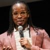 Ibram X. Kendi speaks onstage holding a microphone at the premiere of a Netflix movie.