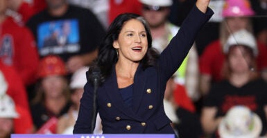 Tulsi Gabbard waves in a blue outfit