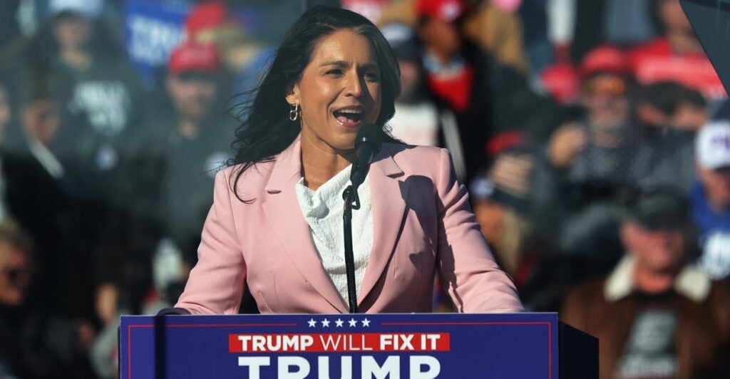 Tulsi Gabbard stands at a podium and speaks at a Donald Trump campaign rally