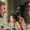 A man and a woman arguing at dinner at a restaurant