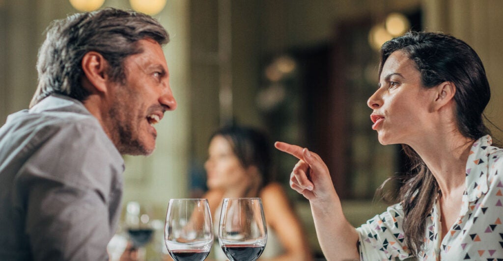 A man and a woman arguing at dinner at a restaurant