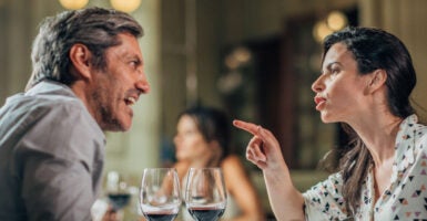 A man and a woman arguing at dinner at a restaurant