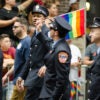 New York City firefighters in uniform March in the annual Gay Pride Parade And wave a Small pride flag