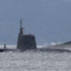 A British navy sub peeking out of the water near shore