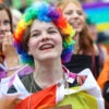 Several gay and transgender teen girls dressed in colorful flags at a parade