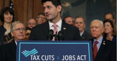 Then-House Speaker Paul Ryan behind a placard touting the 2017 Tax Cuts and Jobs Act