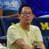 Santa Ono, the president of the University of Michigan, in a yellow T-shirt at a college basketball game